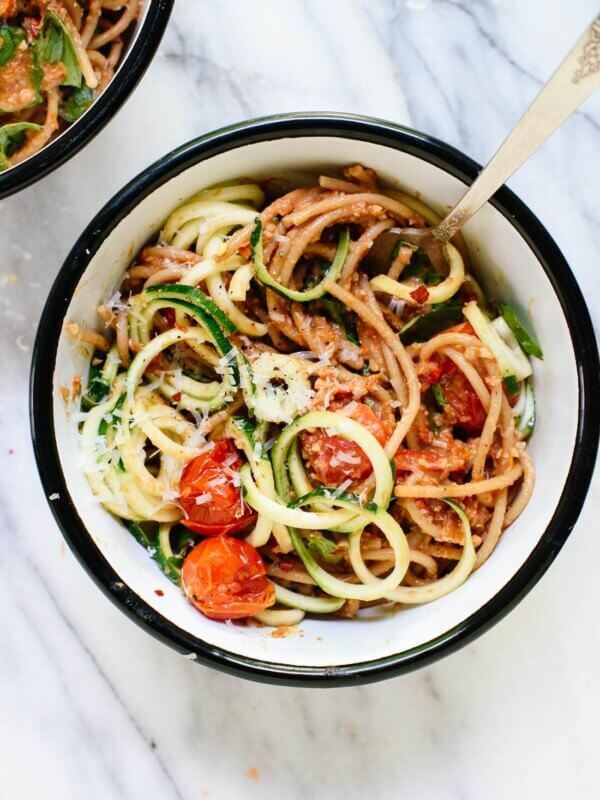 This fresh summer recipe features burst cherry tomatoes, cherry tomato and sun-dried tomato pesto, zucchini noodles, and spaghetti! It's light and delicious. cookieandkate.com