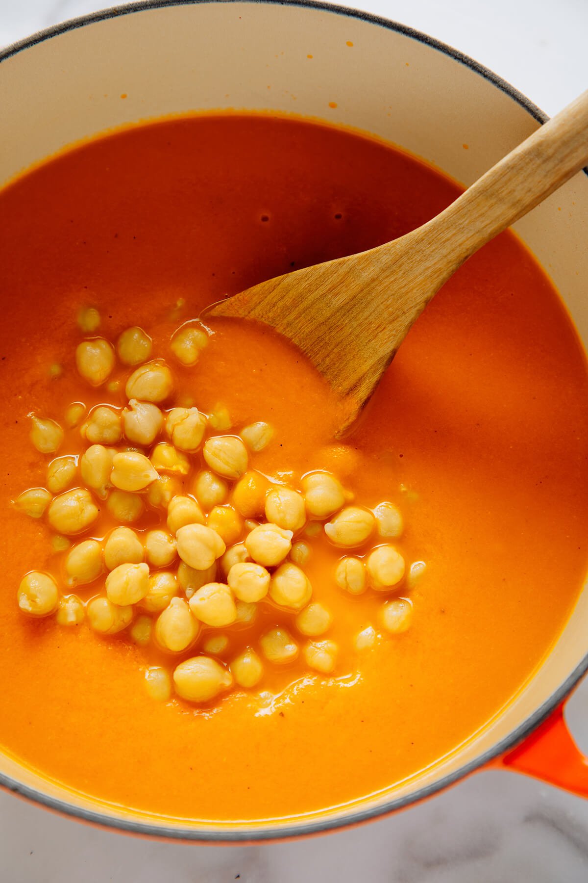 stirring chickpeas into soup