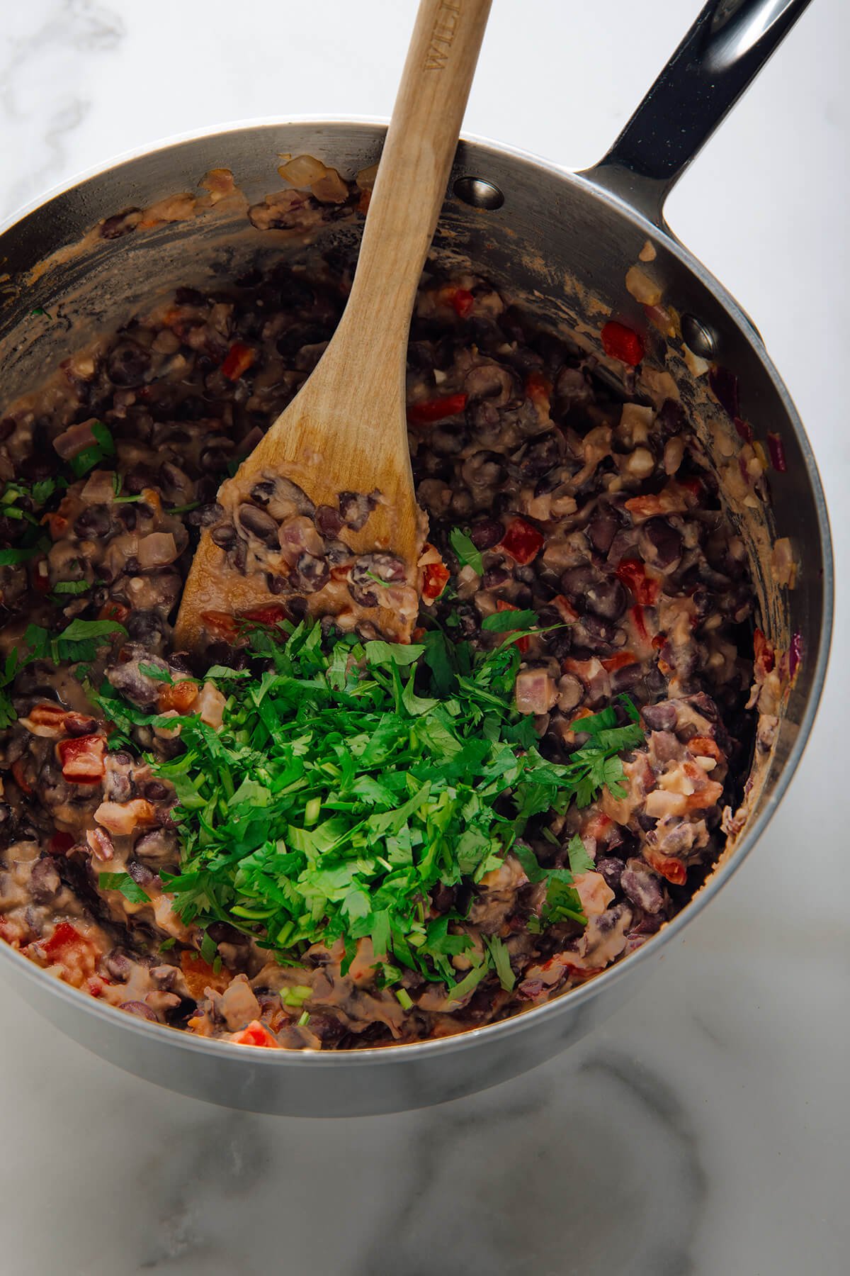 stirring cilantro into refried beans